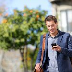 Young urban professional man using smart phone. Businessman hold